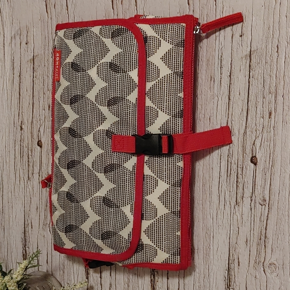 SkipHop  Diaper change pad with storage red black and grey pattern
